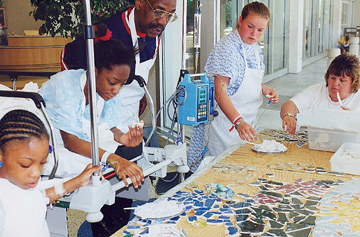 Pediatric hospital patients and community members of differing backgrounds and abilities work together to create a mosaic.